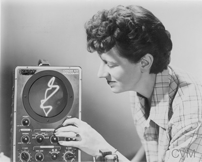 Mary Ellen Bute observing an image on the oscilloscope screen whose knobs and switches she used to “draw with a beam of light” for Abstronic (1952).