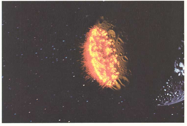 A ring of orange particle-system fire expands across the dark surface of a planet in the Genesis sequence.