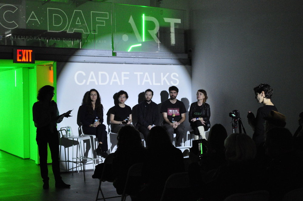 A photograph from the inaugural CADAF in New York: a five-person CADAF Talks panel on stage beneath the fair's illuminated CADAF.ART sign.