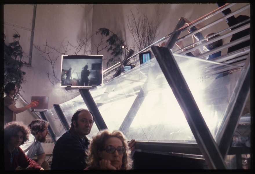 CAVS fellows sit beside an experimental sculpture of metal beams, transparent panels and video monitors.