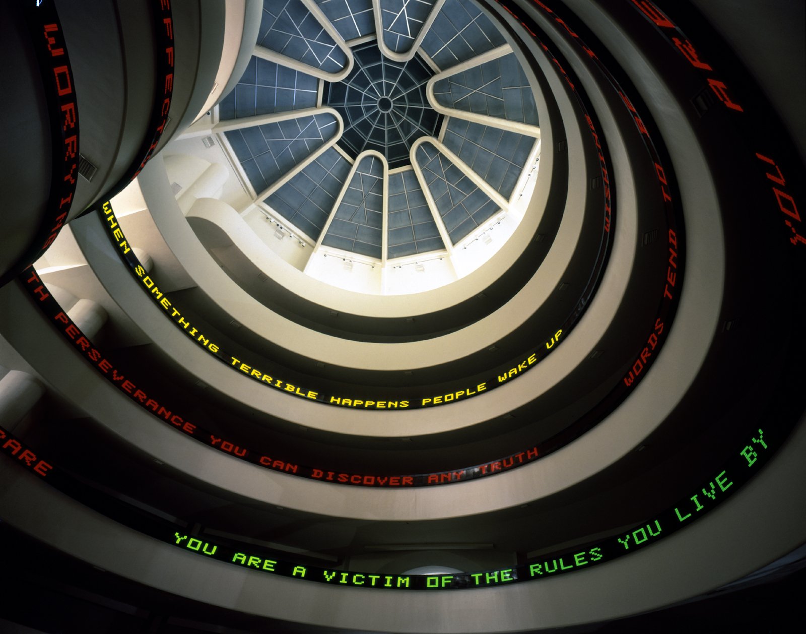 Red, yellow and green LED texts follow the spiral ramps beneath the Guggenheim’s circular skylight.