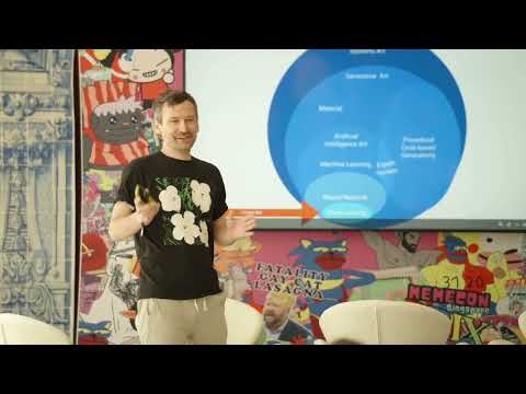 Peter Bauman stands beside a projected diagram explaining categories of artificial intelligence.
