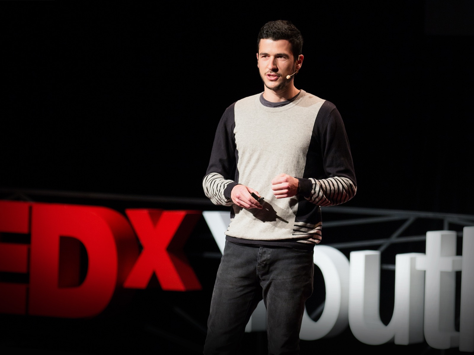Oscar Schwartz on stage delivering his 2015 TEDx talk “Can a computer write poetry?”, the stage photograph published on TED's own talk page.