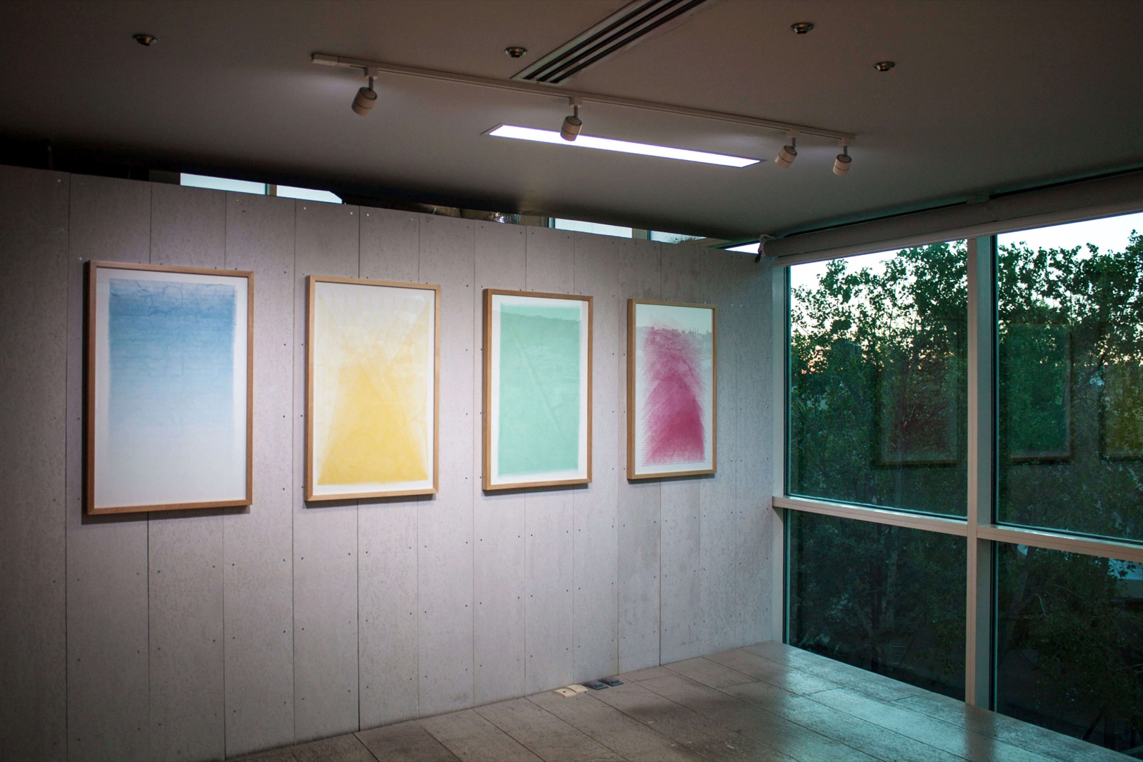 Installation view of Tyler Hobbs's first exhibition, Progress: four framed generative prints hung on a concrete wall beside the gallery's window.