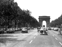 A still from Shigeko Kubota's Europe on 1/2 Inch a Day (1972), the earliest of her Broken Diary video diaries: traffic on the Champs-Élysées shot from a moving car, with the Arc de Triomphe ahead.