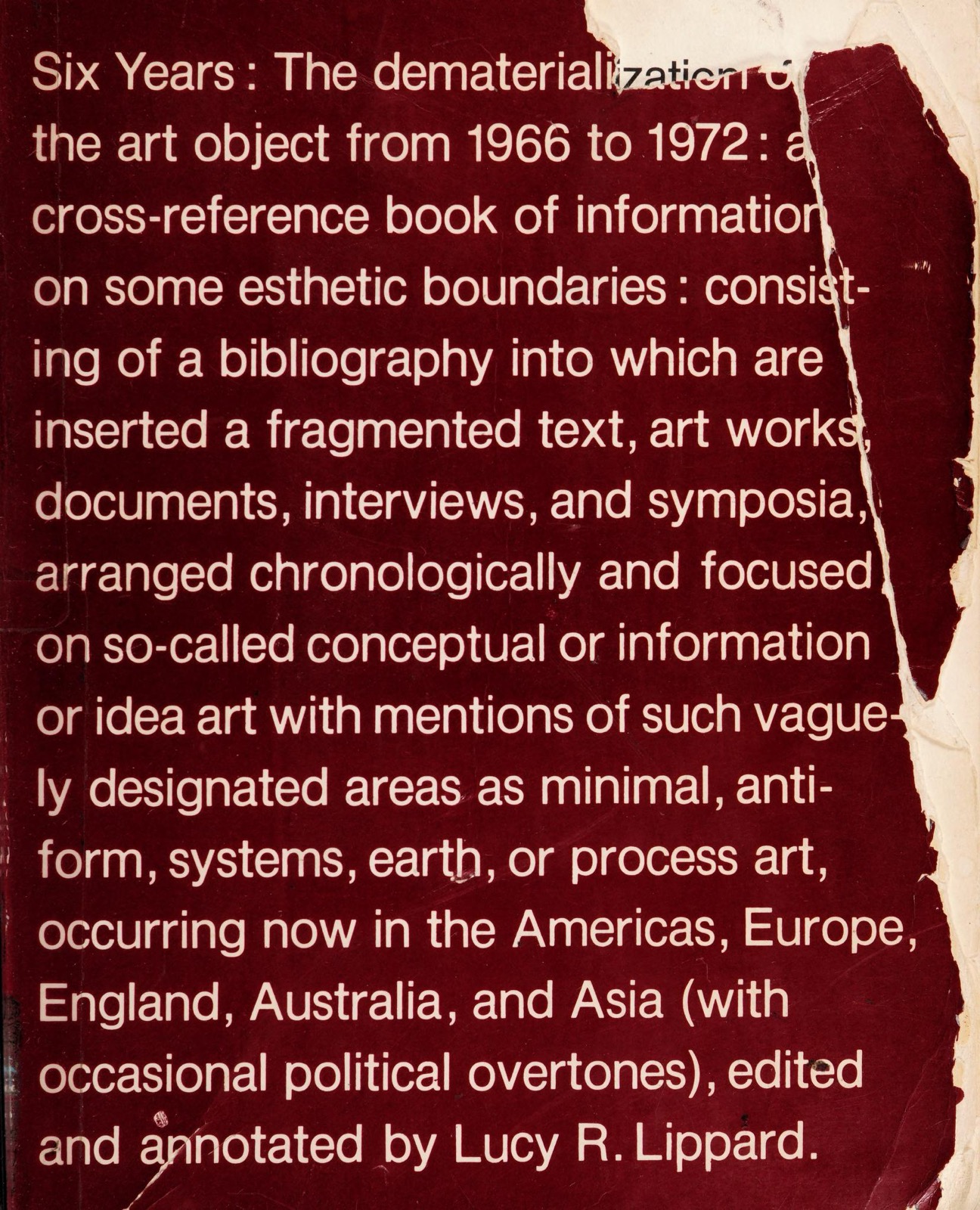 The front cover of the first edition of Lucy Lippard's Six Years (Praeger, 1973), whose entire design is the book's long subtitle set in white sans-serif on dark red, the paper torn away at the right edge of this copy.