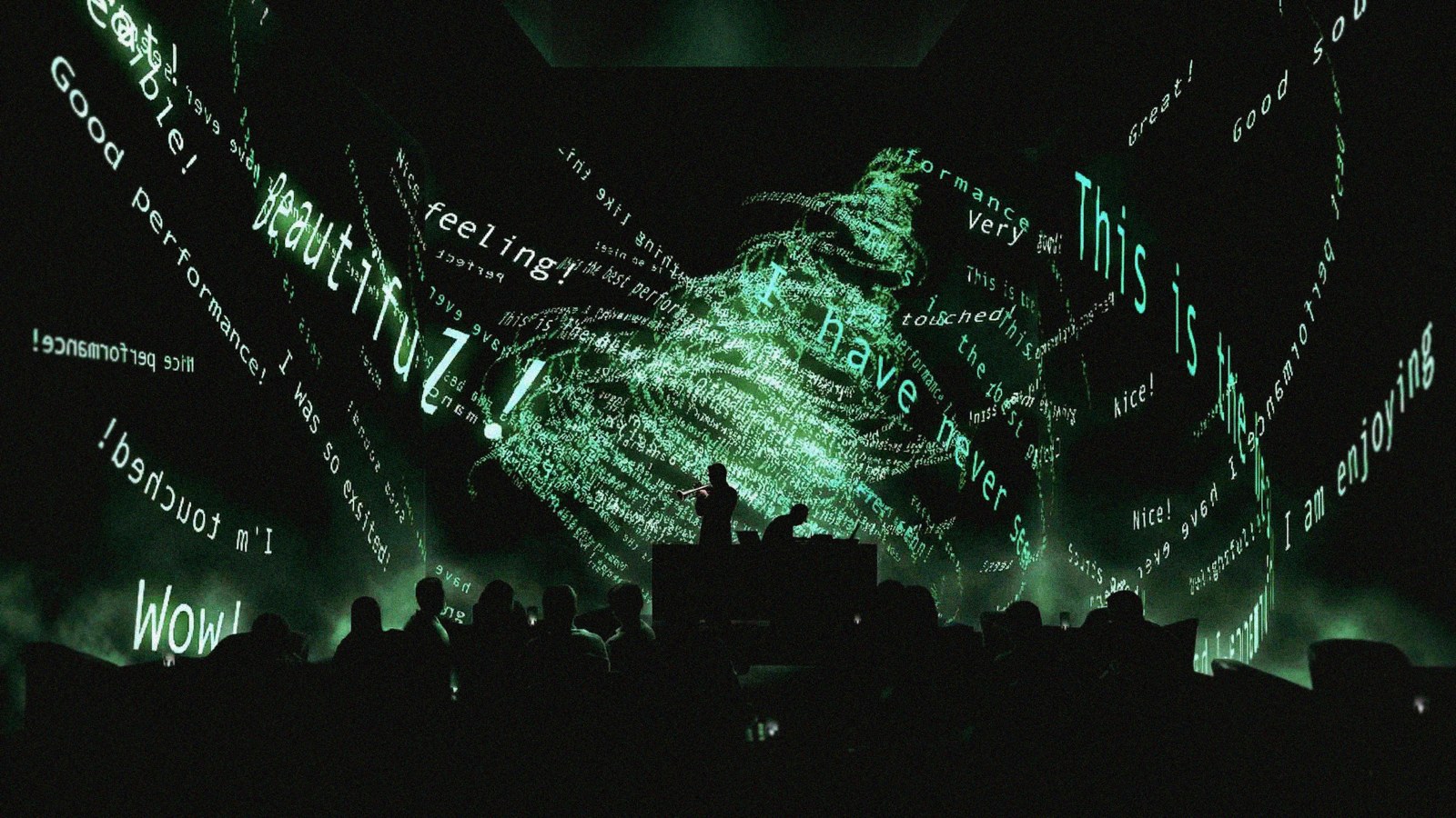 Projected green comments form a tree around live musicians, with audience silhouettes in the foreground.