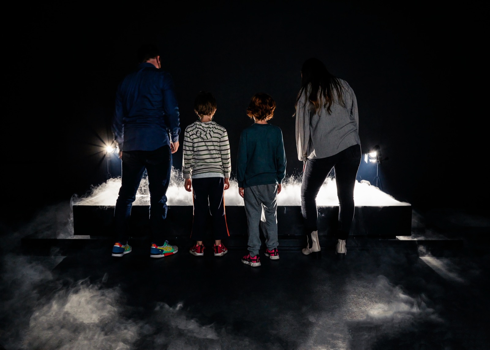 The header image of SFMOMA's Unstable Presence page: four visitors standing at the edge of a low basin of illuminated fog, an installation view of Lozano-Hemmer's Call on Water.