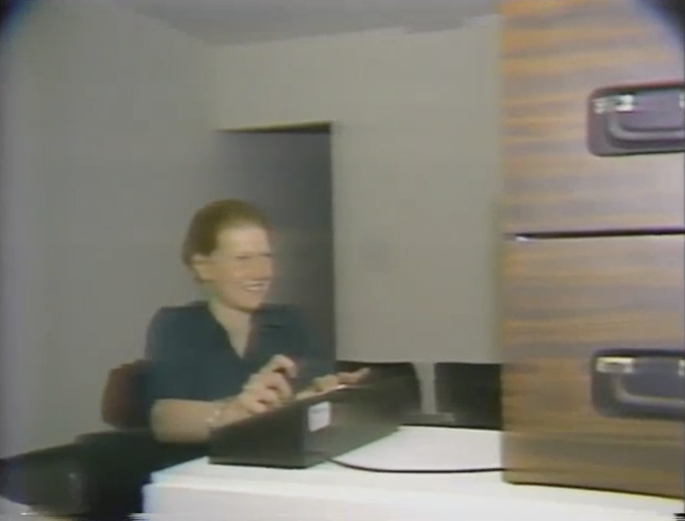 A child operates the installation’s joystick and buttons beside a large wooden monitor cabinet.